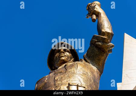 Vista dall'angolo basso di una statua di un soldato che regge una torcia nel monumento Maqam Echahid contro un cielo blu. Foto Stock