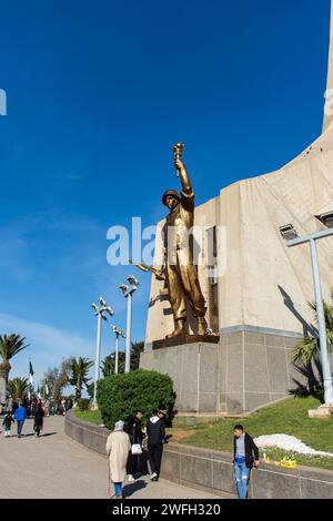 Ammira una statua di un soldato che tiene in mano una torcia e una pistola nel monumento Maqam Echahid nella città di Algeri. Foto Stock