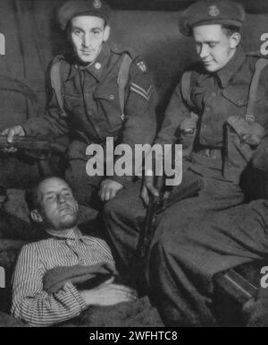 William Joyce alias Lord Haw-Haw sotto guardia dopo la sua cattura il 29 maggio 1945, da parte delle truppe della seconda Armata al confine danese-tedesco. Era un'emittente di propaganda nazista e fascista di origine americana durante la seconda guerra mondiale. Fu successivamente condannato nel Regno Unito per alto tradimento, condannato a morte e impiccato nella prigione di Wandsworth. Foto Stock