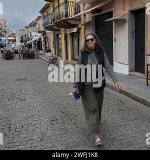 Turista femminile che cammina lungo una strada acciottolata a Santa Teresa Gallura, cittadina sulla punta settentrionale della Sardegna, sullo stretto di Bonifacio, nel p Foto Stock