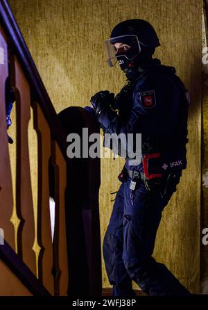 Hohenbostel, Germania. 3 gennaio 2024. Gli agenti di polizia dell'unità di disposizione di Lüneburg esercitano l'ingresso in un edificio. Credito: Philipp Schulze/dpa/Alamy Live News Foto Stock