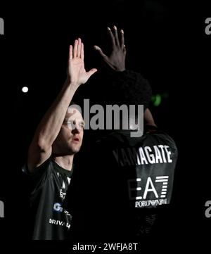 Cinque mani in alto di compagni di squadra di basket Olimpia Milano con sfondo scuro Foto Stock