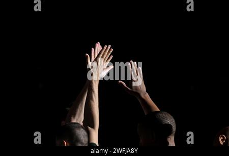 Cinque mani in alto di compagni di squadra di basket Olimpia Milano con sfondo scuro Foto Stock