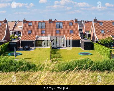 Due case semi-indipendenti con prato e trampolino rotondo incassato nel giardino sul retro, Colijnsplaat, Noord-Beveland, Zelanda, Paesi Bassi Foto Stock