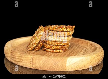 Diversi biscotti talleri dolci su un piatto di legno, macro, isolati su fondo nero. Foto Stock
