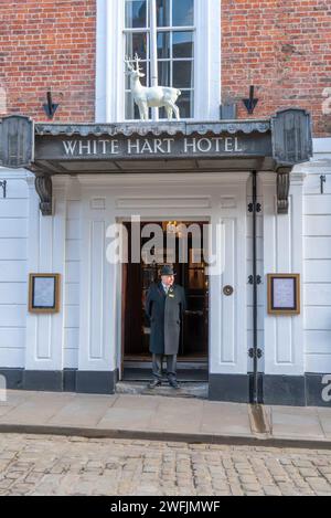 Commissionario del White Hart Hotel in piedi davanti alla porta dei visitatori più famosi, Bailgate, Lincoln City, Lincolnshire, Inghilterra, REGNO UNITO Foto Stock