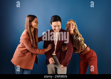 adolescenti multirazziali in abiti vivaci che si divertono sullo sfondo blu, giorno dell'amicizia Foto Stock