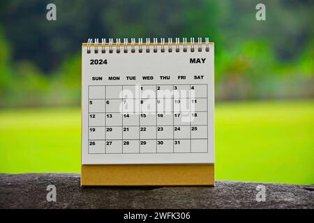 Maggio 2024 calendario bianco con sfondo sfocato verde. Foto Stock