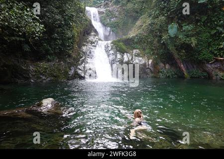 Lady che nuota in piscina presso le incredibili cascate, il Pico Bonito National Park, l'Honduras, l'America centrale Foto Stock