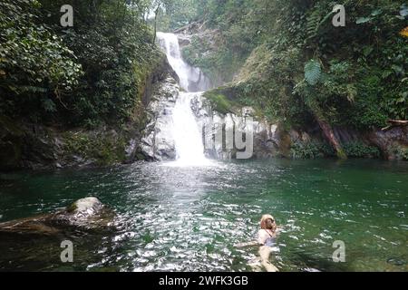 Lady che nuota in piscina presso le incredibili cascate, il Pico Bonito National Park, l'Honduras, l'America centrale Foto Stock