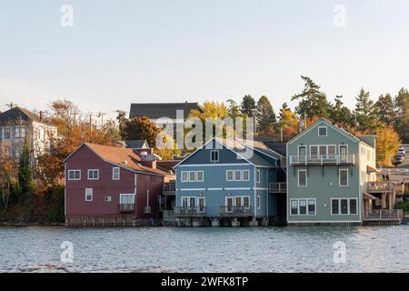 Foto orizzontale di un gruppo di edifici storici colorati costruiti su pilastri sopra Penn Cove a Coupeville, Whidbey Island, Washington State. Foto Stock