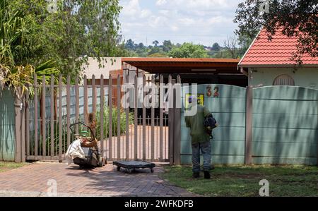 Johannesburg, Sudafrica - un lavoratore migrante non identificato fa lavori manuali di giardinaggio per guadagnarsi da vivere Foto Stock