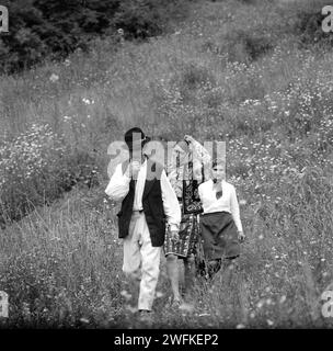 Contea di Vrancea, Repubblica Socialista di Romania, ca. 1977. I contadini che scendono da una collina indossano i loro costumi tradizionali. Foto Stock