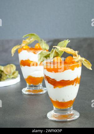 Dessert stratificato con yogurt proteico e frutta fisalis Foto Stock