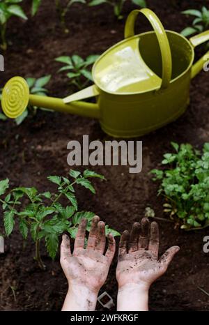 Una giovane donna mostra le sue mani sporche agglomerate dopo aver lavorato nel suo piccolo giardino cittadino. Foto Stock