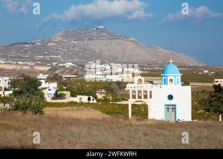 Santorini - La piccola cappella oltre ad Akrotiri e monte Profitis Ilias in backgroud. Foto Stock