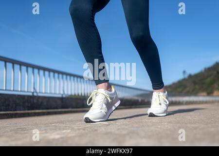 primo piano di scarpe da corsa, donna che corre su una strada Foto Stock