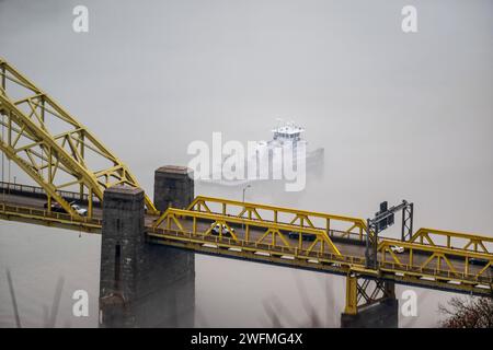 Una towboat naviga attraverso la nebbia sotto il West End sul fiume Ohio a Pittsburgh, 25 gennaio 2024. Il U.S. Army Corps of Engineers Pittsburgh District gestisce 23 chiuse navigabili e dighe sui fiumi Allegheny, Monongahela e Ohio tutto l'anno, indipendentemente dalle condizioni meteorologiche, anche in condizioni di nebbia che limitano la visibilità. Molti equipaggi di barche a rimorchio continuano a lavorare sui fiumi anche nella nebbia, talvolta mettendo in scena le loro chiatte lungo varie parti lungo i corsi d'acqua di Pittsburgh mentre aspettano che la nebbia si sollevi. Indipendentemente dal tempo, le chiuse e le dighe del distretto di Pittsburgh rimangono aperte Foto Stock