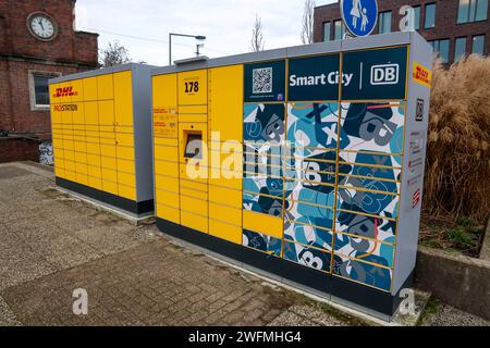 Bahnhofs-Packstation von DHL und Deutsche Bahn am Bahnhof Rheine. Nicht nur DHL kann die Stationen beliefern, sondern auch lokale Händler. Serviceangebot am Bahnhof verbessert. Rheine, Nordrhein-Westfalen, DEU, Deutschland, 30.01.2024 *** DHL e Deutsche Bahn stazione di imballaggio presso la stazione Rheine non solo DHL può consegnare alle stazioni, ma anche rivenditori locali offerta di servizio presso la stazione migliorata Rheine, North Rhine-Westphalia, DEU, Germania, 30 01 2024 Foto Stock