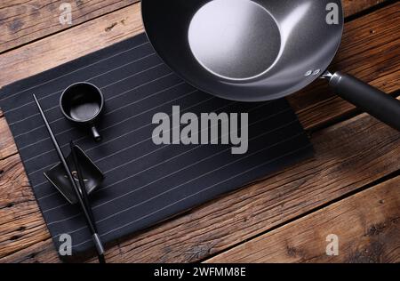 Ferro da stiro vuoto, ciotola per la salsa e bacchette su un tavolo di legno Foto Stock