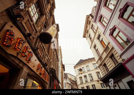 Un cartello luminoso e una bottiglia enorme di Beer Planet store in Rue de la Fourche Street nel 45 a Bruxelles. Vista grandangolare "guardando in alto" sulla strada in città. Foto Stock