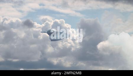 UFO. Astronave aliena che si presenta dalle nuvole nel cielo. Visitatori extraterrestri Foto Stock