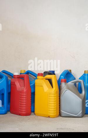 vecchi contenitori di olio in plastica usati, galloni chimici per olio motore o motore per il riciclaggio, varie dimensioni e colori di contenitori di rifiuti vuoti o taniche bianche Foto Stock