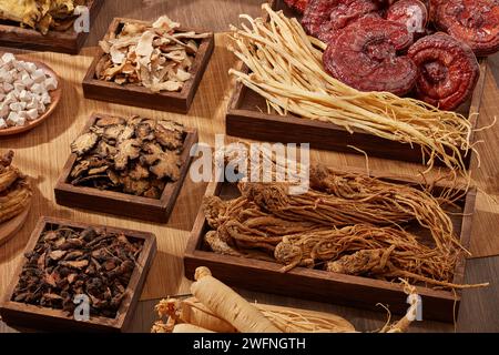 Una varietà di erbe sono esposte su vassoi di legno a forma quadrata e rettangolare. La medicina tradizionale cinese è molto preziosa e usata per prevenire o t Foto Stock