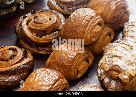 Vista ravvicinata dei dolci al cioccolato, dei croissant alle mandorle e della deliziosa salsa danese con uva passa a spirale. Foto Stock