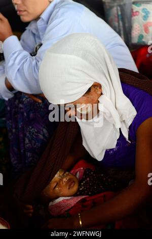 Una donna Arakanese che allatta il suo bambino sul traghetto tra Sittwe e Mrauk-U nel Myanmar occidentale. Foto Stock