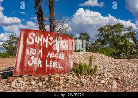 Un cartello dipinto su un cofano rosso seduto su una remota collina rocciosa vicino a Lightning Ridge nel New South Wales, Australia. Foto Stock