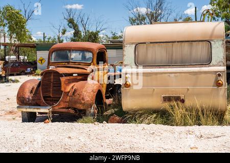 Un camion arrugginito accanto a una vecchia carovana a sinistra sulla strada vicino a Lightning Ridge, nel nuovo Galles del Sud, Australia. Foto Stock