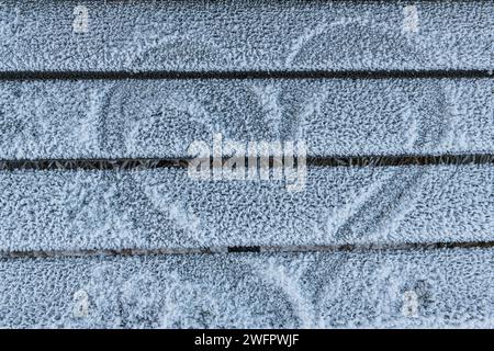 Questa immagine cattura l'intricato dettaglio del gelo che si è depositato su tavole di legno, evidenziando la texture e i motivi creati dal freddo Foto Stock