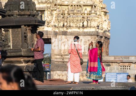 Belur, Karnataka, India - 9 gennaio 2023: Una donna indiana che scatta foto con il suo telefono nello storico complesso del tempio di Chennakeshava. Foto Stock