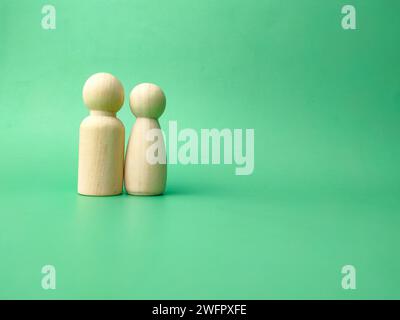 Coppia di bambole di legno su sfondo verde con spazio per copie Foto Stock