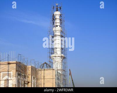 Cairo, Egitto, 20 gennaio 2024: Un sito di costruzione di una nuova moschea con una struttura in acciaio della cupola e delle impalcature lungo tutto il minareto del Masji Foto Stock