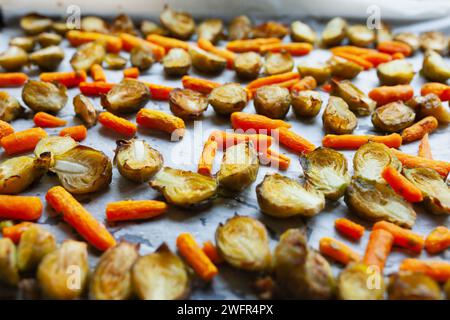 Carote arrostite e cavoletti di bruxelles a fette su una teglia da forno Foto Stock