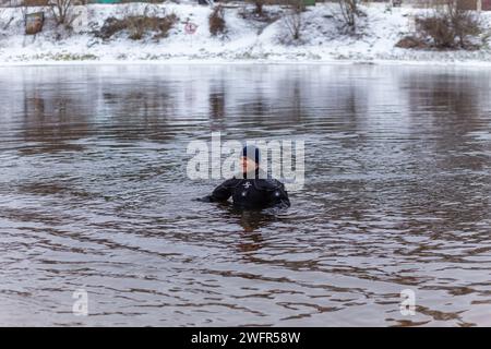 Grodno, Bielorussia - 28 gennaio 2024: Un subacqueo del servizio di soccorso è in servizio in acqua in caso di emergenza durante la tradizionale temperatura annuale Foto Stock