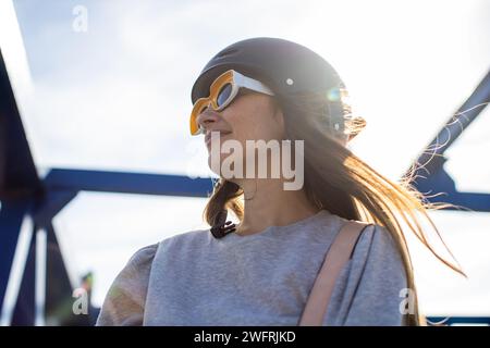 giovane donna con elmetto da bicicletta sorridente Foto Stock