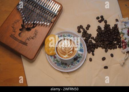 Vista dall'alto di una tazza di caffè caldo con chicchi di caffè sul tavolo Foto Stock