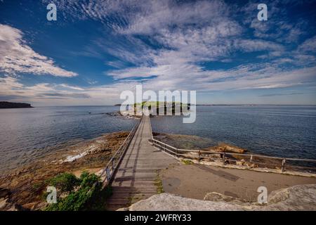 Il molo di legno si estende verso l'oceano da una costa rocciosa. Sydney, Australia Foto Stock