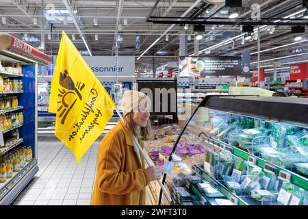 © PHOTOPQR/LE DAUPHINE/Grégory YETCHMENIZA ; Annecy ; 01/02/2024 ; Annecy, le 1 février. Une trentaine de membres de la conféderation paysanne de Haute-Savoie, accompagnée d'une dizaine de membres de la CGT, mènent depuis 9h45 ce matin une opération dans le carrefour d'Annecy situé avenue de Genève. Dans le supermarché, ils ciblent trois produits : les 'contrefactions' de reblochon, les tomates hors saison, et le mille non francais vendu sous l'appellation miel francais. Avec cette action, ils revendiquent des revenus décents, notamment via l'interdiction d'achat en dessous des prix de revient Foto Stock