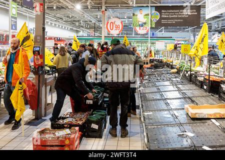 © PHOTOPQR/LE DAUPHINE/Grégory YETCHMENIZA ; Annecy ; 01/02/2024 ; Annecy, le 1 février. Une trentaine de membres de la conféderation paysanne de Haute-Savoie, accompagnée d'une dizaine de membres de la CGT, mènent depuis 9h45 ce matin une opération dans le carrefour d'Annecy situé avenue de Genève. Dans le supermarché, ils ciblent trois produits : les 'contrefactions' de reblochon, les tomates hors saison, et le mille non francais vendu sous l'appellation miel francais. Avec cette action, ils revendiquent des revenus décents, notamment via l'interdiction d'achat en dessous des prix de revient Foto Stock