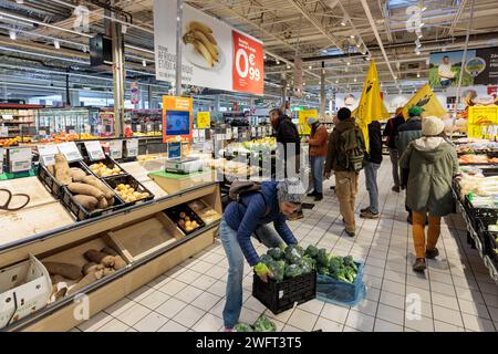 © PHOTOPQR/LE DAUPHINE/Grégory YETCHMENIZA ; Annecy ; 01/02/2024 ; Annecy, le 1 février. Une trentaine de membres de la conféderation paysanne de Haute-Savoie, accompagnée d'une dizaine de membres de la CGT, mènent depuis 9h45 ce matin une opération dans le carrefour d'Annecy situé avenue de Genève. Dans le supermarché, ils ciblent trois produits : les 'contrefactions' de reblochon, les tomates hors saison, et le mille non francais vendu sous l'appellation miel francais. Avec cette action, ils revendiquent des revenus décents, notamment via l'interdiction d'achat en dessous des prix de revient Foto Stock