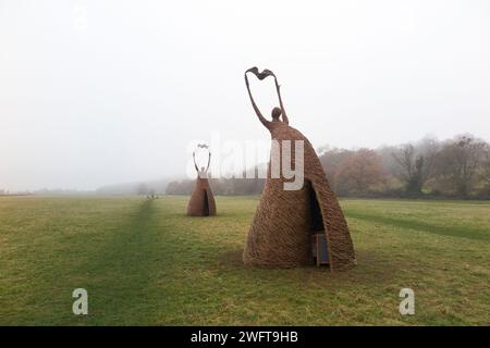 Scultura di una donna che rilascia uccello (forse una colomba di pace), realizzata con rami di salice, dall'artista Willowtwisters in residenza, in mostra a Runnymede, nel Surrey. REGNO UNITO. Foto Stock