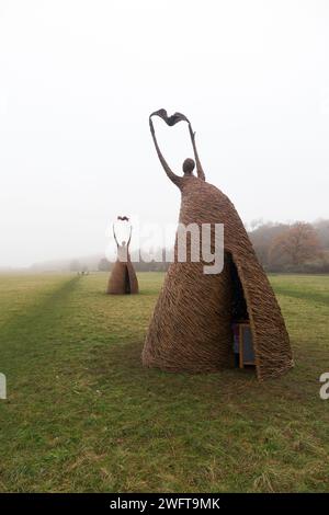 Scultura di una donna che rilascia uccello (forse una colomba di pace), realizzata con rami di salice, dall'artista Willowtwisters in residenza, in mostra a Runnymede, nel Surrey. REGNO UNITO. Foto Stock