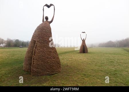 Scultura di una donna che rilascia uccello (forse una colomba di pace), realizzata con rami di salice, dall'artista Willowtwisters in residenza, in mostra a Runnymede, nel Surrey. REGNO UNITO. Foto Stock