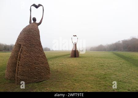 Scultura di una donna che rilascia uccello (forse una colomba di pace), realizzata con rami di salice, dall'artista Willowtwisters in residenza, in mostra a Runnymede, nel Surrey. REGNO UNITO. Foto Stock