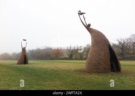 Scultura di una donna che rilascia uccello (forse una colomba di pace), realizzata con rami di salice, dall'artista Willowtwisters in residenza, in mostra a Runnymede, nel Surrey. REGNO UNITO. Foto Stock