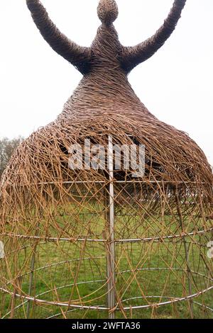 Scultura di una donna che rilascia uccello (forse una colomba di pace), realizzata con rami di salice, dall'artista Willowtwisters in residenza, in mostra a Runnymede, nel Surrey. REGNO UNITO. Foto Stock